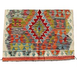 Afghan Chobi Kilim ivory ground rug, central geometric design consisting of stacked lozenge medallions in shades of red, green, and blue, flanked by multicoloured triangular motifs, guarded by zigzag patterns in contrasting tones