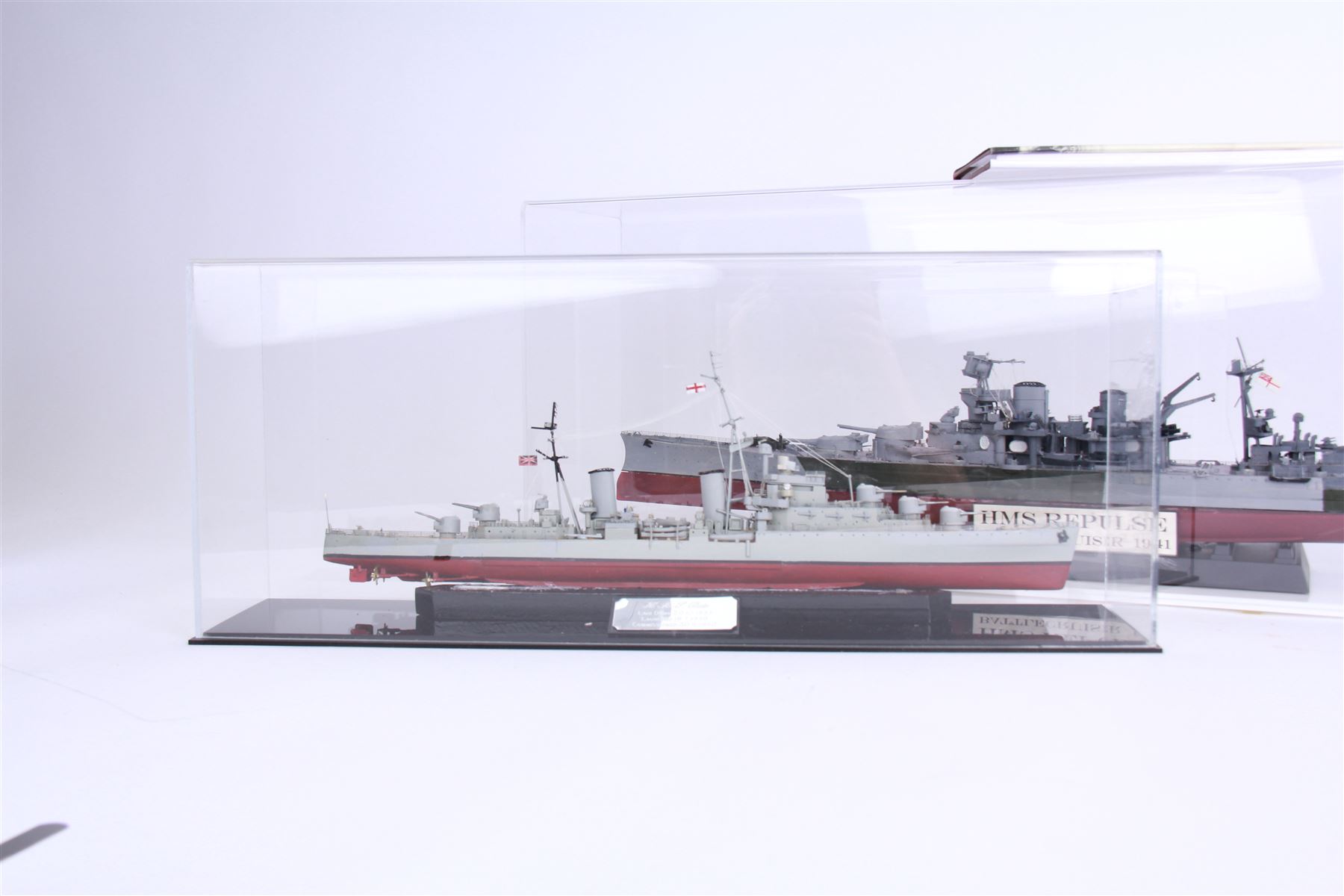 Two ship models in display cases; HMS Repulse, 1941 and HMS Dido, 1939, together with a book about HMS Dido, largest H27cm 
