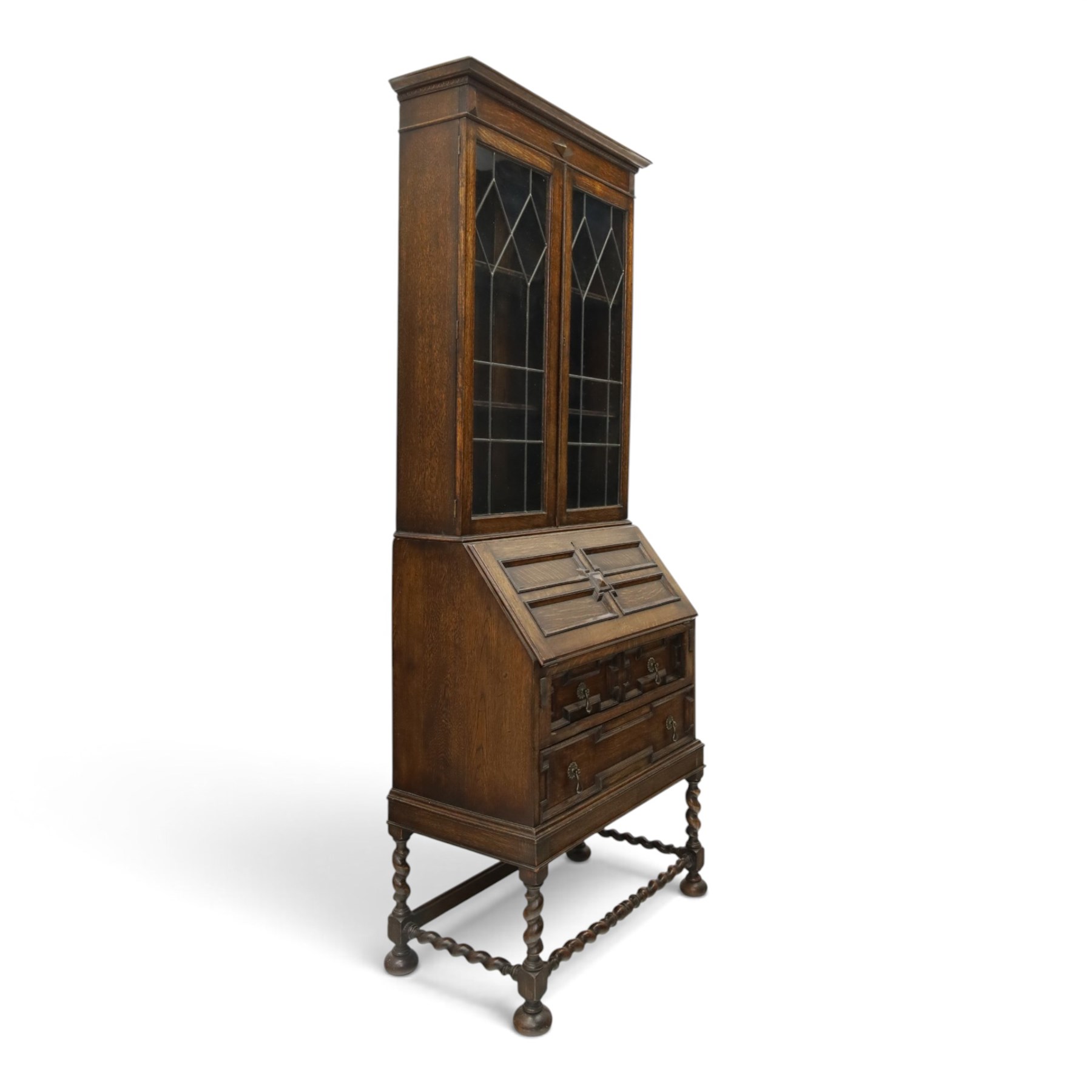 Early 20th century Jacobean Revival oak bureau-bookcase, astragal glazed doors enclosing two adjustable shelves, over geometric panelled fall-front enclosing fitted interior, over two drawers, raised on a spiral-turned base with barley-twist stretchers and compressed bun feet