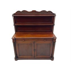 Victorian mahogany chiffonier side cabinet, the cresting rail carved with scroll leafage over two tier shelf back, moulded top over single drawer and double panelled cupboard, turned and fluted pilaster columns