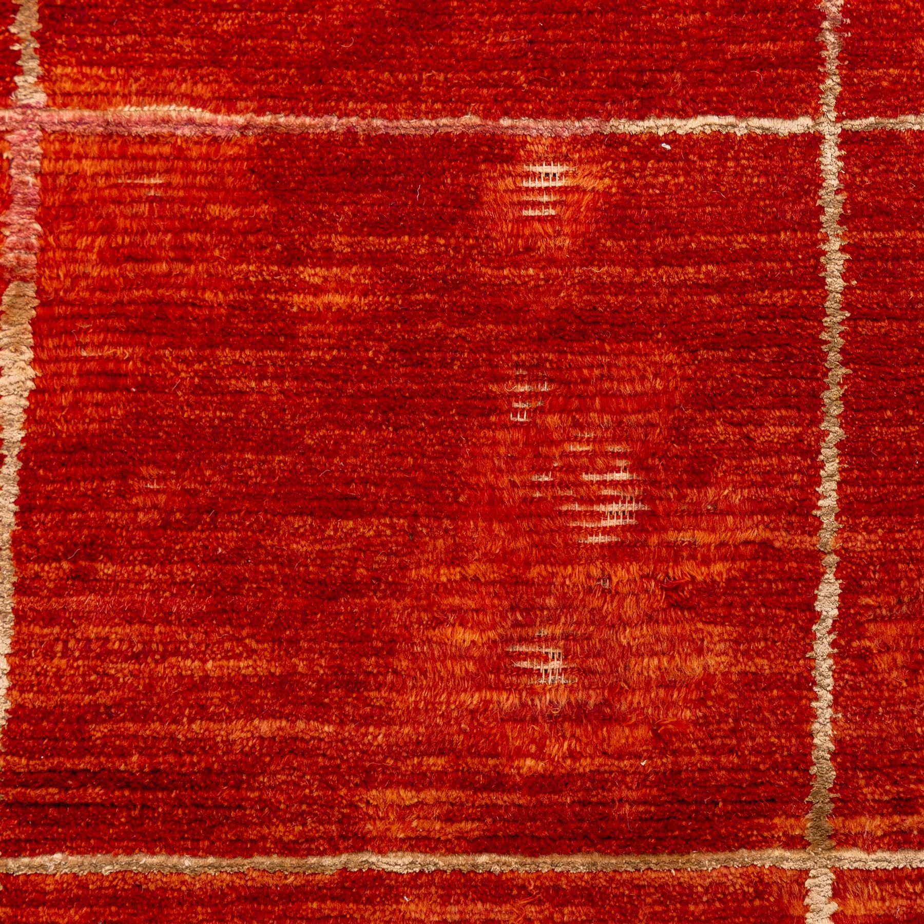 Two contemporary Moroccan Berber hand-woven rugs, deep madder red field of plain design, 199x153cm, other with deep madder red field with a simple lattice of ivory lines forming panels with some tonal variation, 190x146cm 