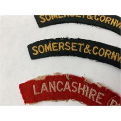 Pair of Civil Defence Corps armbands; and three cloth shoulder titles for Somerset & Cornwall L.I (2), Lancashire (PWV) and Devon & Dorset Regiments (6)