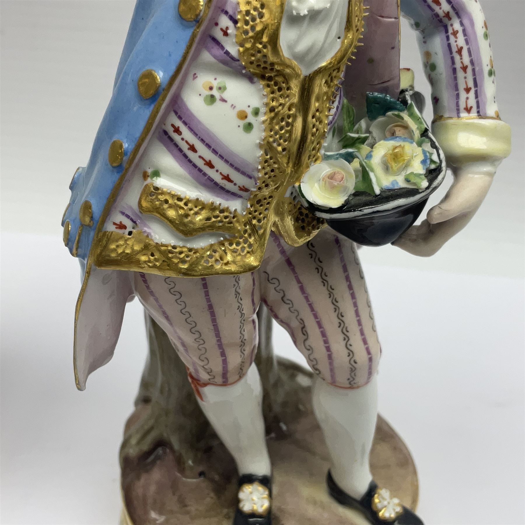 Pair of late 19th/early 20th Century Meissen figures, modelled as flower sellers, after the original by Michel Victor Acier, she holding basket of flowers, he holding flowers in his hat, each with underglaze cross swords mark beneath, tallest H16.5cm