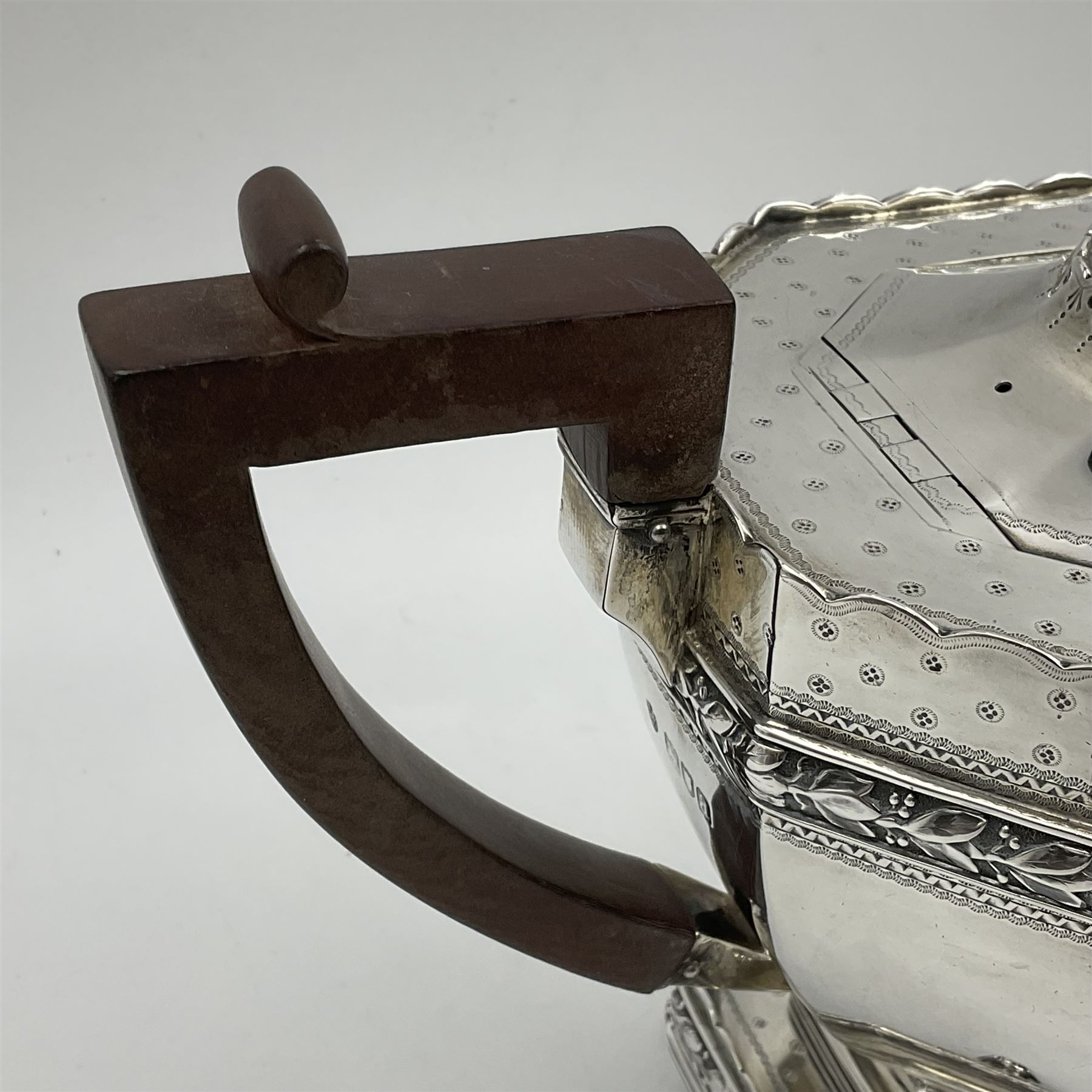 Victorian silver four piece tea service, comprising teapot, teapot stand, twin handled open sucrier and milk jug, each of octagonal form with foliate bud border and engraved decoration including crest to canted panels, and vacant panels, the teapot with ivory finial to the hinged cover and later wooden handle, hallmarked Edward Barnard & Sons Ltd, London1896, teapot including finial H15cm, milk jug including handle H16cm, teapot stand W11.5cm

This item has been registered for sale under Section 10 of the APHA Ivory Act