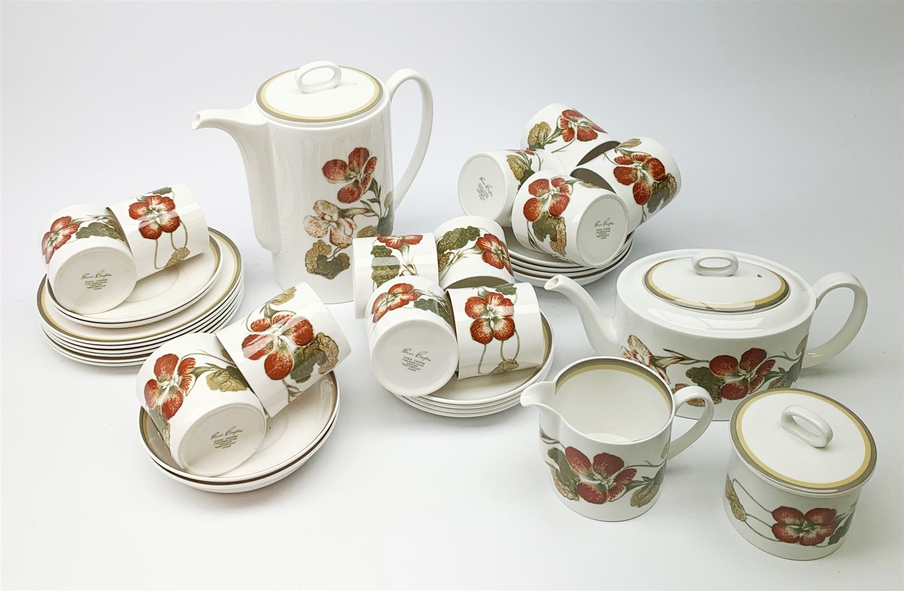A Susie Cooper Nasturtium pattern tea service, comprising tea pot, coffee pot, six tea cups and six saucers, six coffee cans and six saucers, six side plates, milk jug, and lidded sucrier. 