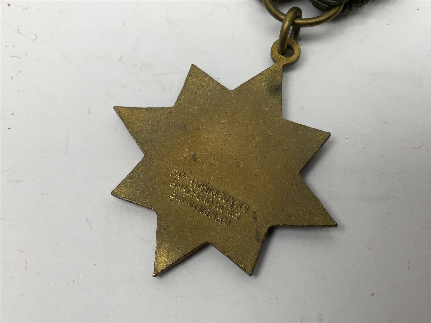 Made-up group of three WWI medals comprising 1914 Star awarded to 23598 Gnr. F. Jefferson R.G.A., British War Medal and Victory Medal with names removed; with ribbons on wearing bar; 1942 Motorist's Medal and small quantity of cap badges, Royalty badges etc