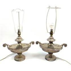 A pair of silver plated table lamps, of urn form with twin scroll handles and acanthus detail, raised upon circular feet, with floral tasselled shades, overall H63cm. 