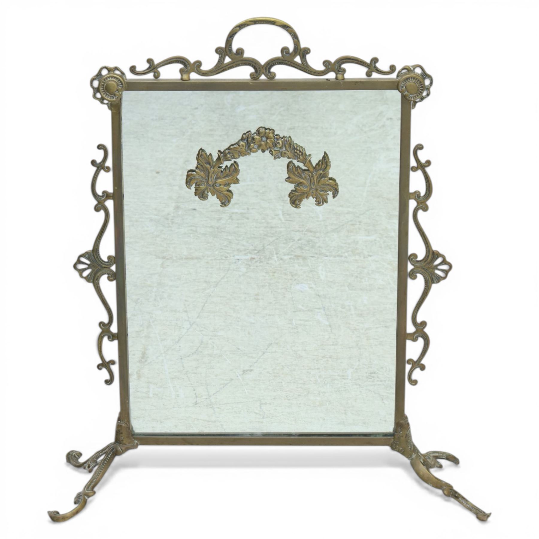 Mirrored brass firescreen, with scrolled frame on scrolled legs 