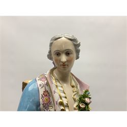 Large pair of late 19th century Continental figures in the Meissen style, modelled as a gardener and companion in 18th century dress, holding baskets of flowers and posies, each upon naturalistically modelled floral encrusted square base with scroll moulded sides, with underglaze blue cross sword type marks beneath, tallest example H49cm