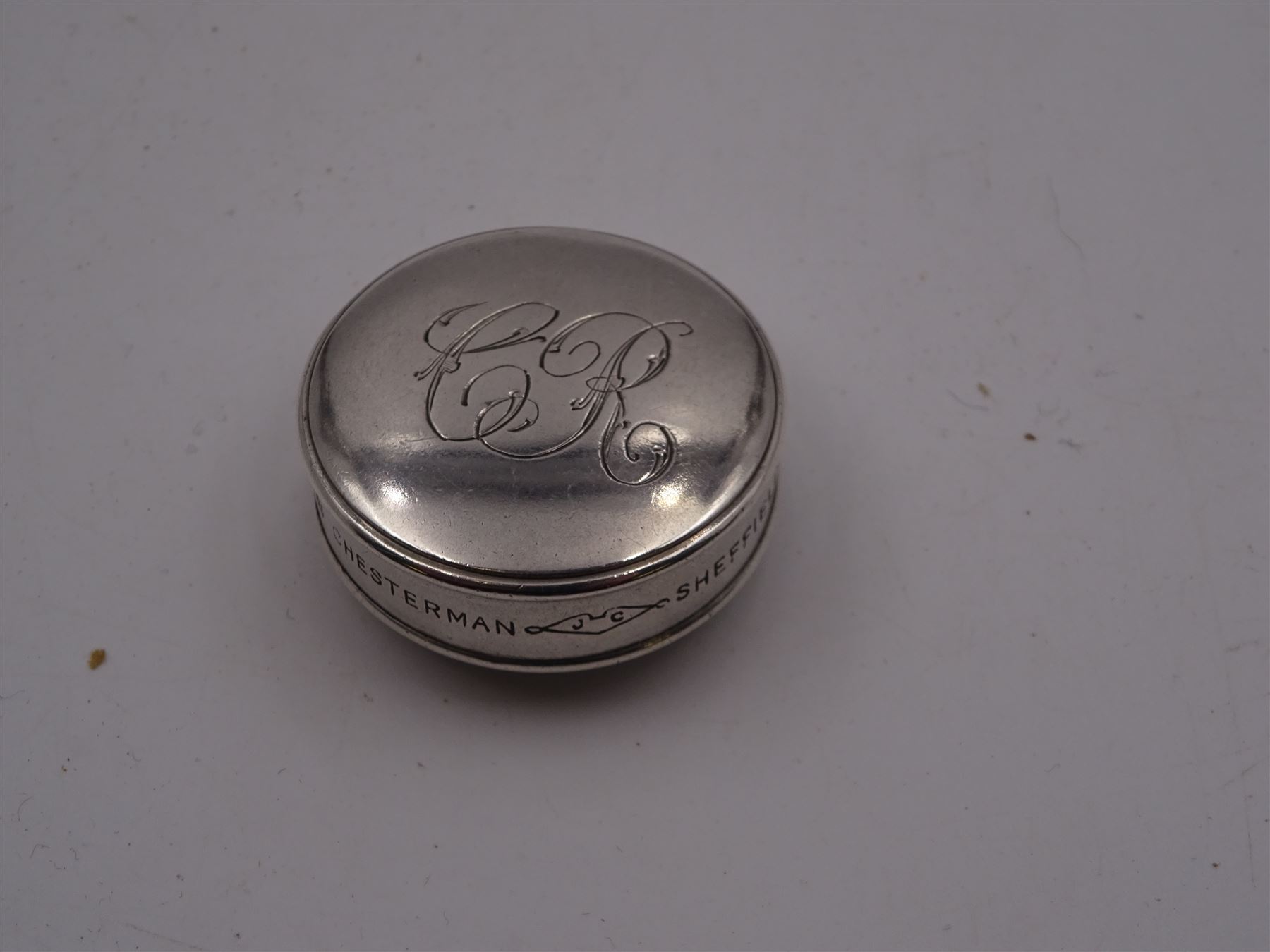 Early 20th century silver tape measure, of circular form, engraved with monogram, inscribed Chesterman Sheffield England to edge, hallmarked James Chesterman & Co, Sheffield 1912 together with a 1930s silver cheroot holder case, hallmarked Joseph Gloster Ltd, Birmingham 1938 containing a cheroot holder with hallmarked 9ct gold collar 