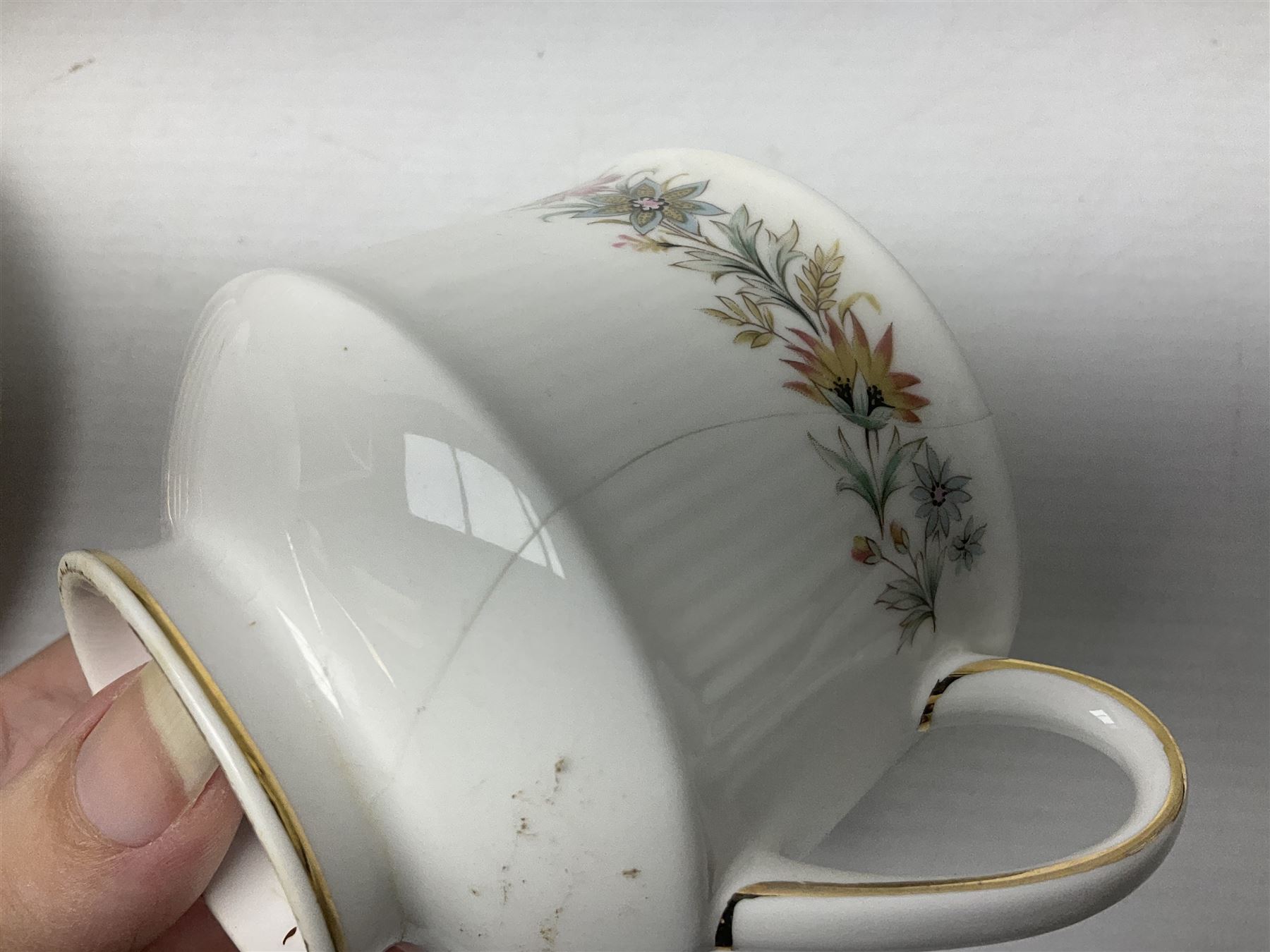 Royal Albert Paragon tea and dinner service for twelve decorated in the Belinda pattern, comprising fourteen saucers, twelve teacups, thirteen side plates, teapot, sauce boat and stand, salt and pepper shakers, two jugs, sucrier, twelve dinner plates, twelve smaller plates, two lidded tureens, twelve bowls, twelve smaller bowls, cake plate, oval plate and oval dish (100)