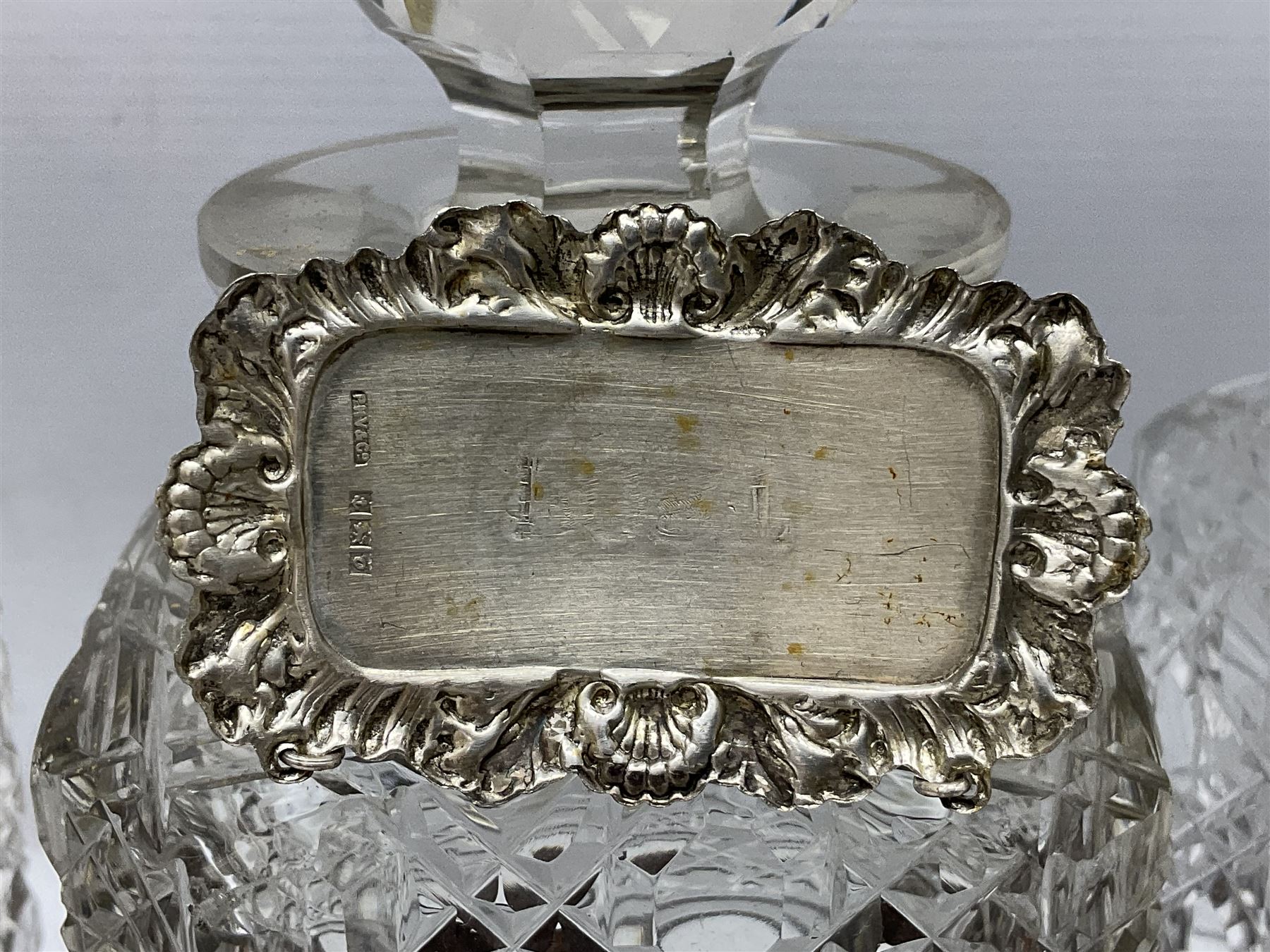 Edwardian oak three bottle tantalus, with brass mounts and three square sided cut glass decanters each with hallmarked silver decanter labels, complete with key, H31cm