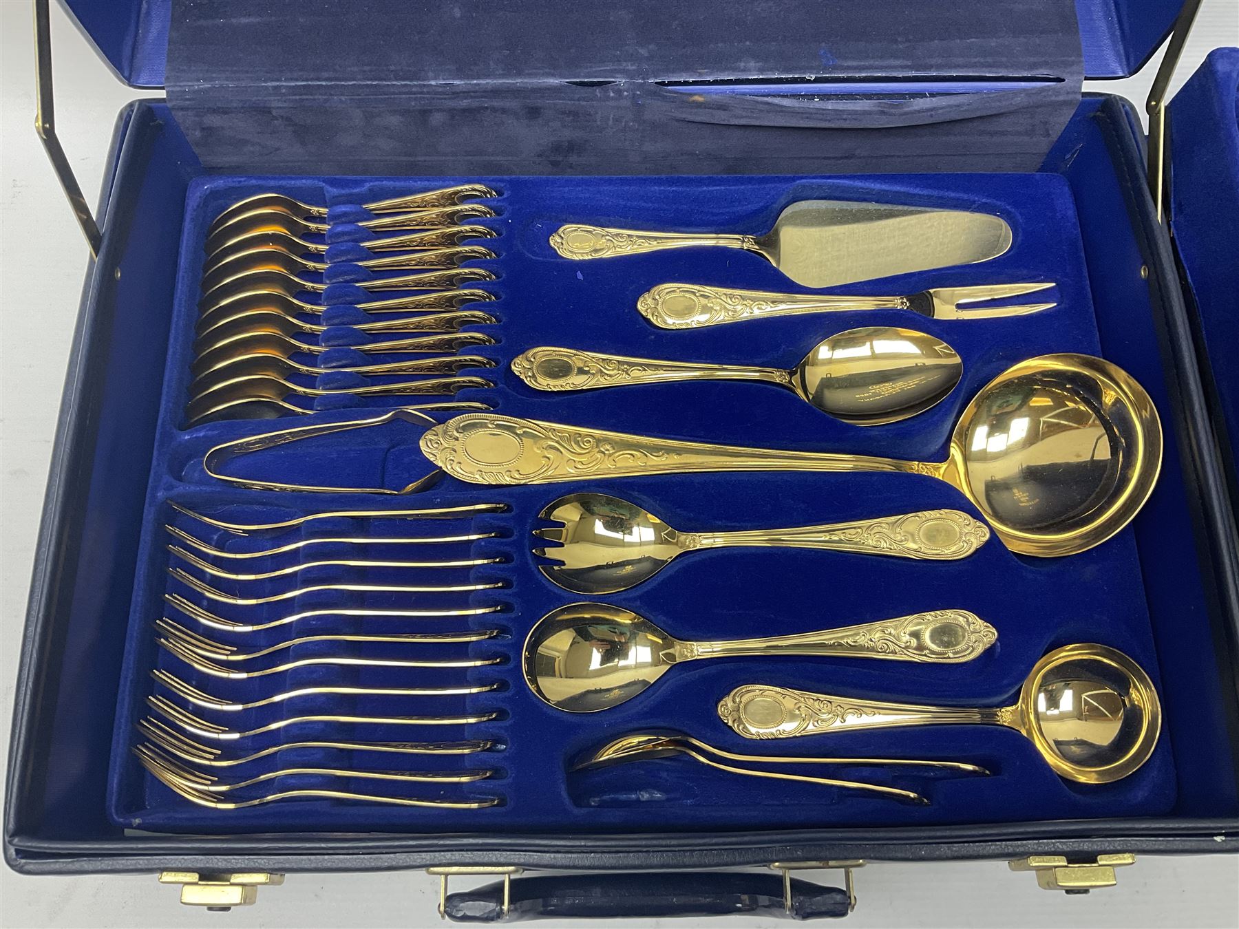 Bestecke Solingen canteen of gold plated cutlery for twelve place settings, including ladle, cake slice, fish servers, fish knives and forks, 108 pieces total, contained within a briefcase 