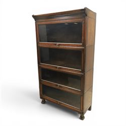 Harris Lebus - oak barrister stacking bookcase, four tier design with glazed fronts with brass knobs, raised on claw and ball feet