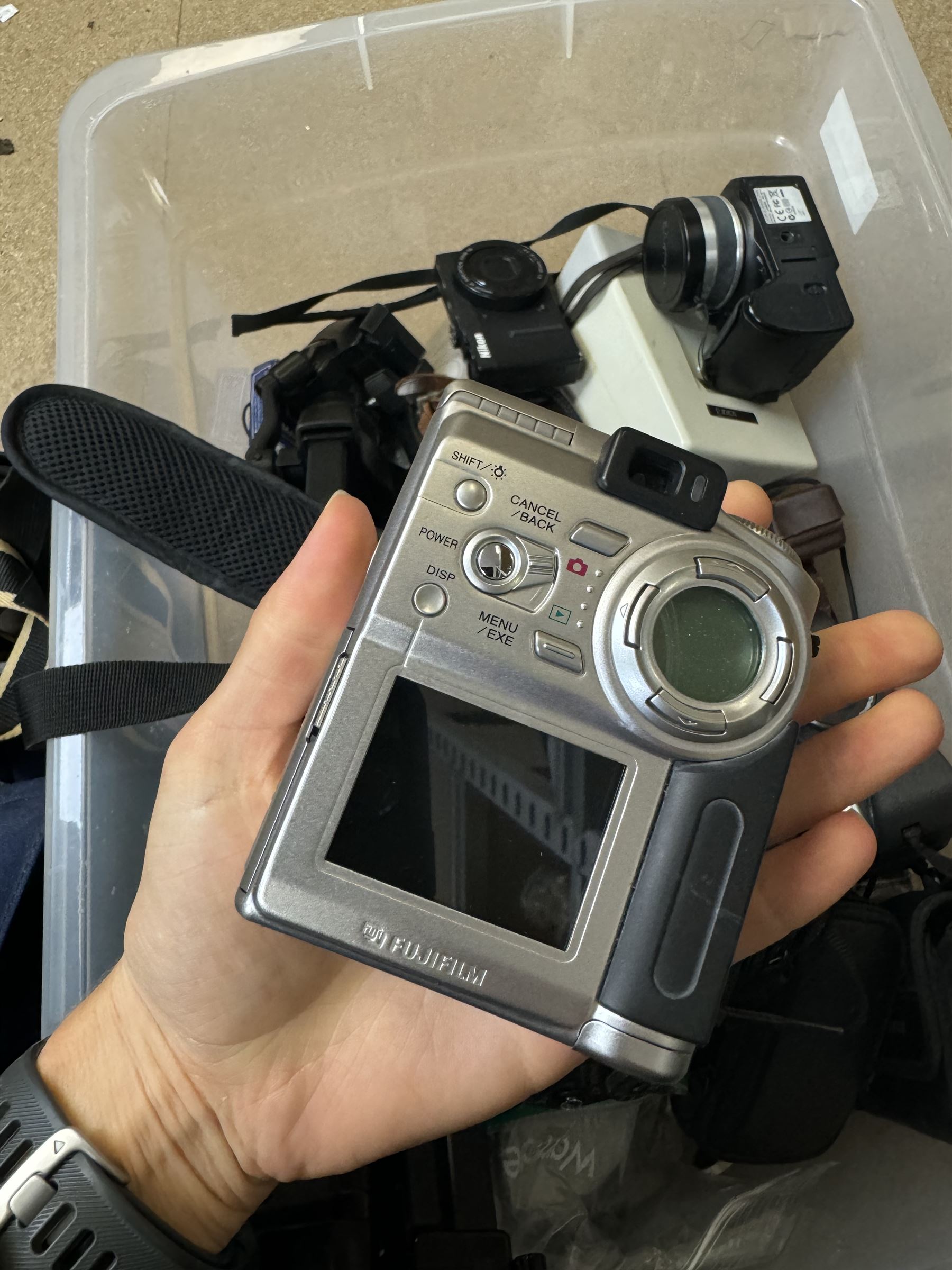 Collection of cameras and camera equipment, including Voigtlander Vitomatic I, Nikon Coolpix P340, Nikon Coolpix S9100, Olympus SP-510UZ, tripod, cases, etc