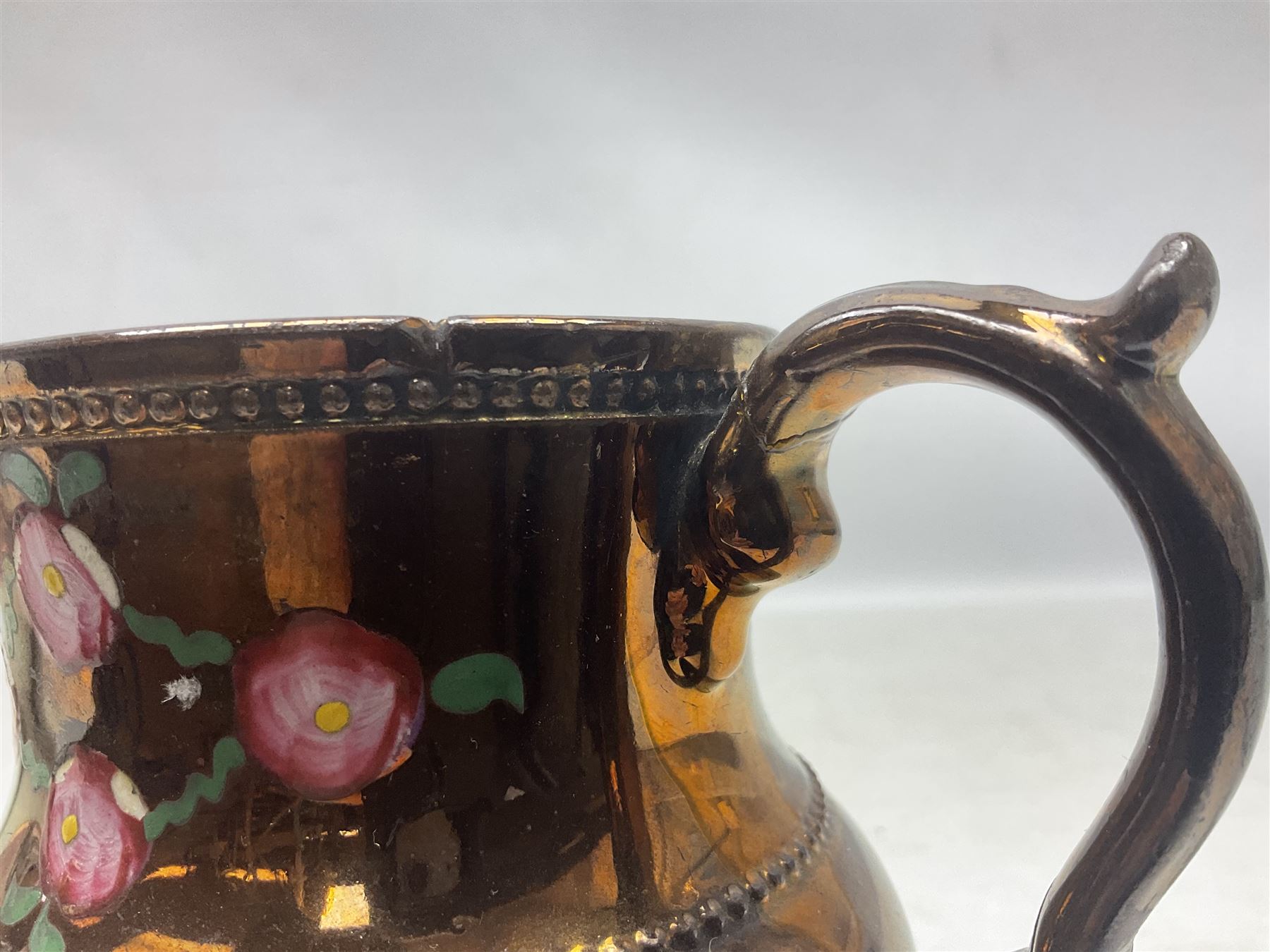 Early 20th century Sunderland lustre jug, decorated with transfer Masonic scene and poem 'The World is in Pain/Our Secrets to Gain/But Still Let Them Wonder and Gaze/The Never Can Divine/The World Nor The Sign/Of a Free and Accepted Mason', the reverse decorated with Sunderland River Wear cast iron bridge scene below text (a/f), together with a copper lustre jug, and pink lustre bowl, jug H20cm