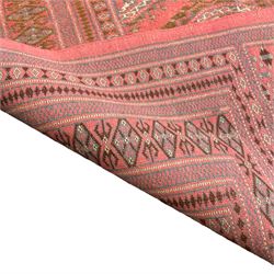 Persian pink ground Bokhara style rug, the field decorated with Gul motifs, repeating borders