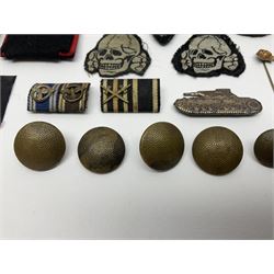 Collection of eleven German metal and cloth badges and uniform buttons including driver's badge, two 'SS' fabric skulls, private's shoulder tabs, Police cloth badge, tank destruction badge, medal bars and ribbon etc; most WW2 period