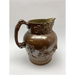 19th century salt glazed stoneware jug, with mask spout and greyhound modelled handle, the body decorated in relief with Royal Coat of Arms flanked by lions, the rim with the flowers of the union, roses, thistles and shamrocks, H26.5cm