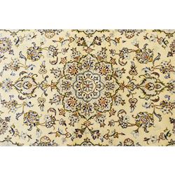 West Central Persian Sarough hand-knotted rug, ivory field with central lobed medallion issuing an all-over design of scrolling vines, palmettes, and floral sprays within conforming spandrels enclosed by a complementary foliate border flanked by guard stripes, with cotton fringe ends 
