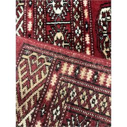 Persian Bokhara rug, red ground and decorated with single row of Gul motifs, multiple band border with geometric design
