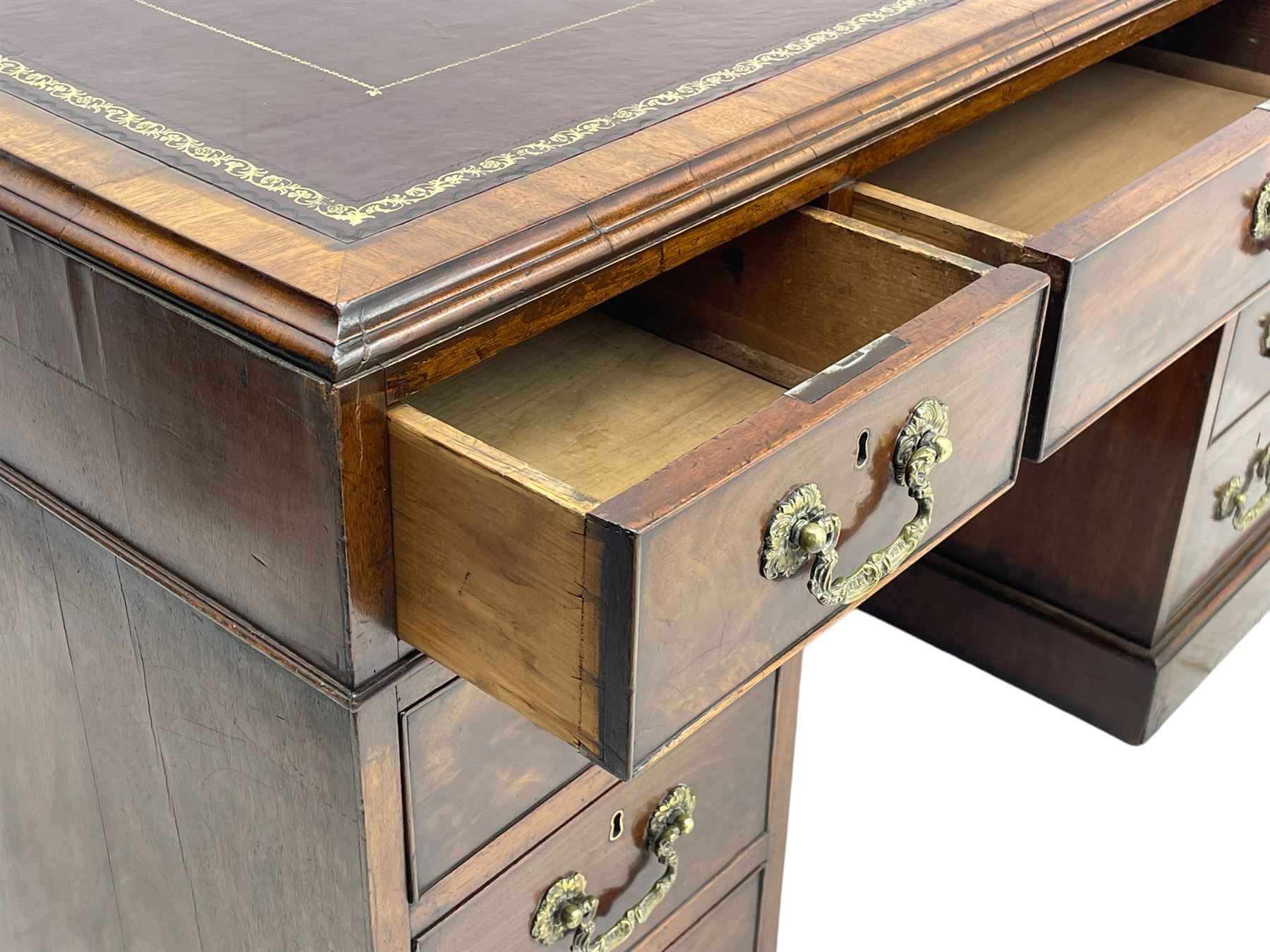 George III mahogany twin pedestal partner's desk, moulded rectangular caddy top with tooled leather inset, one side fitted with nine drawers and the opposing side fitted with single drawer, two false drawers and two panelled cupboards, ornate cast gilt metal handles and handle plates, on plinth base