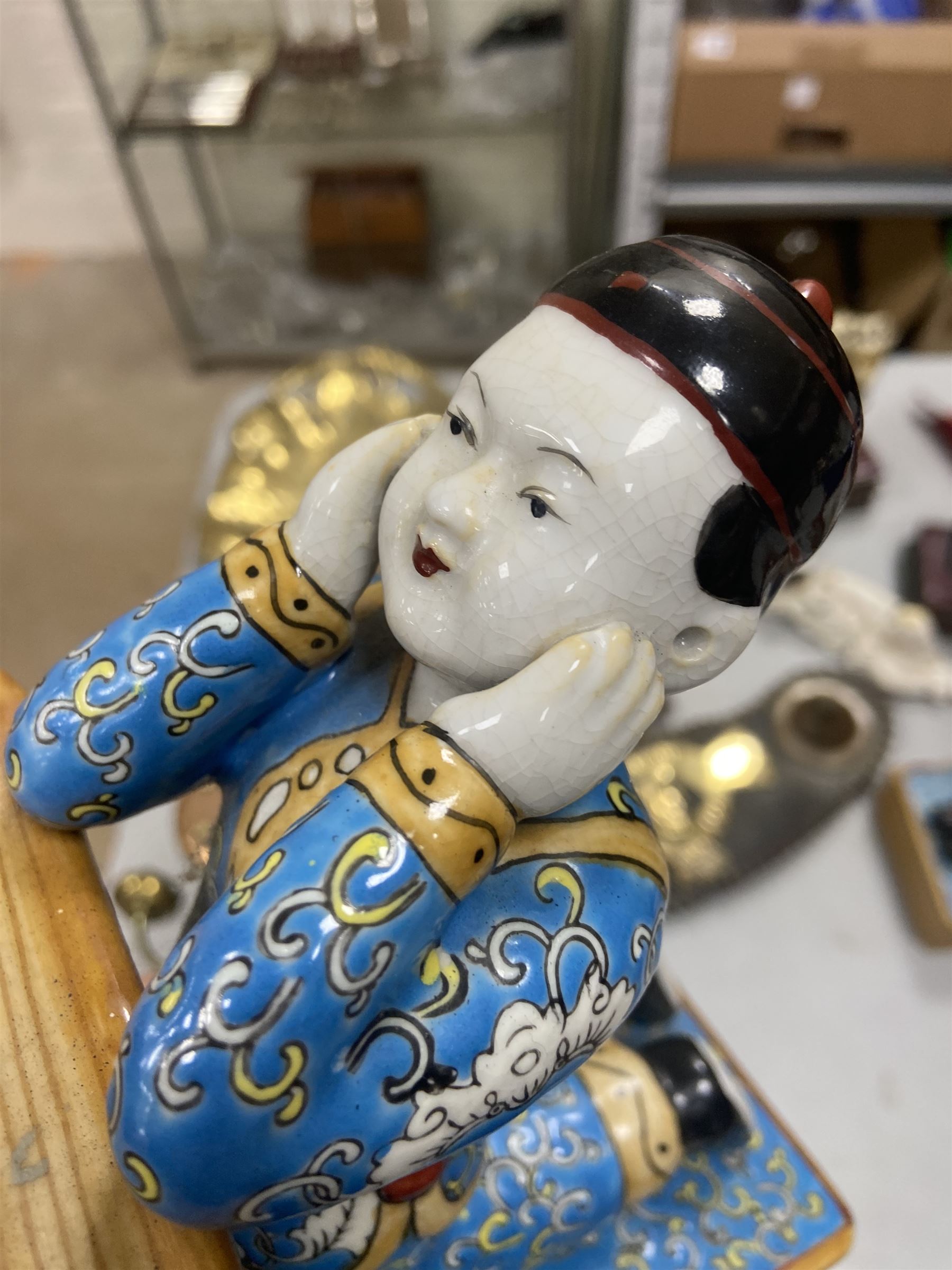 Pair of 20th century Chinese figural bookends, modelled as children in traditional blue dress sat reading and kneeling upon stacks of books, H22cm