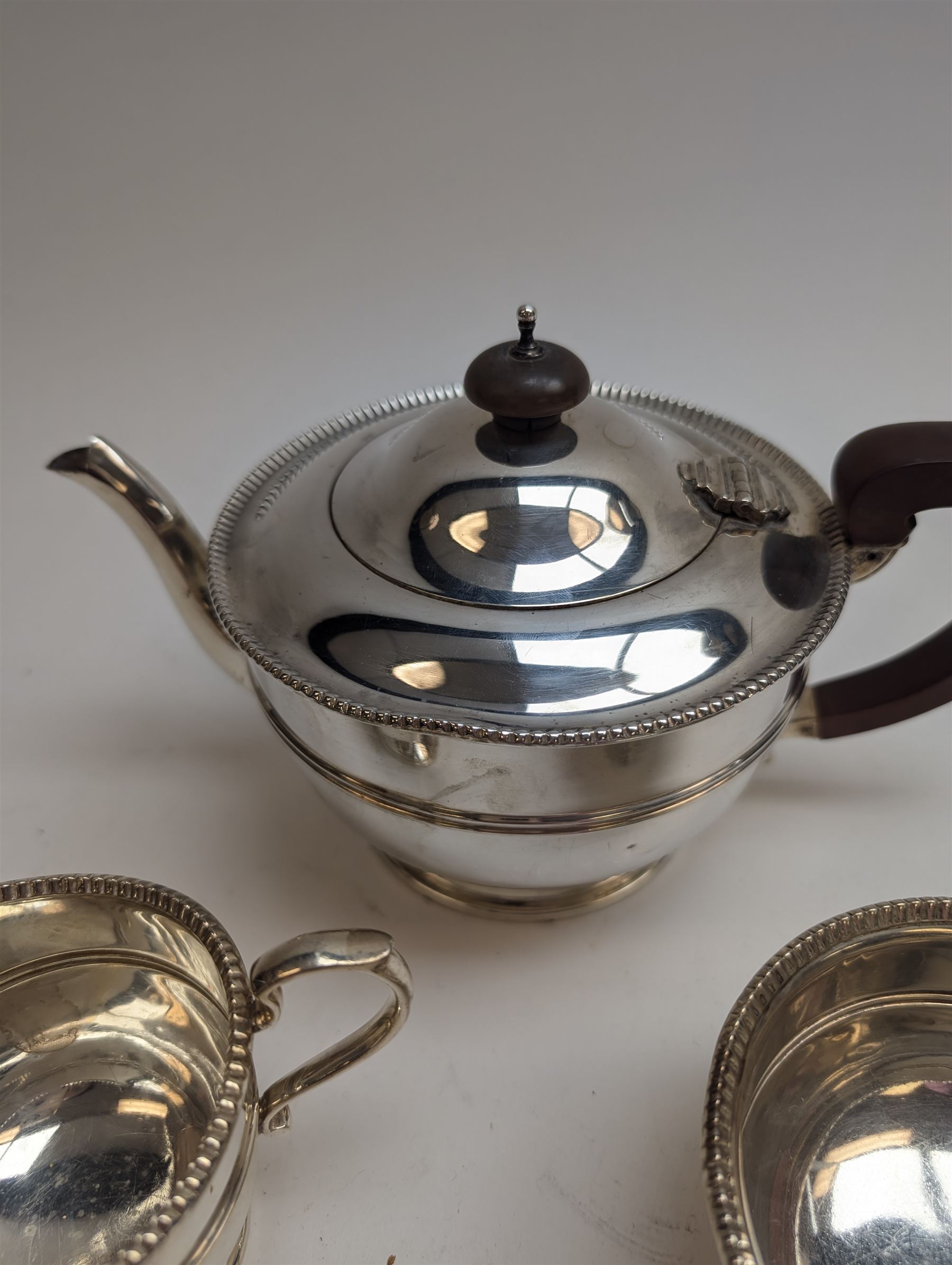 1930s silver three piece tea service, comprising teapot, milk jug and sugar bowl, each of circular form with oblique gadrooned rim, the teapot with Bakelite handle and finial, hallmarked Mappin & Webb Ltd, Birmingham 1931, teapot H14.5cm