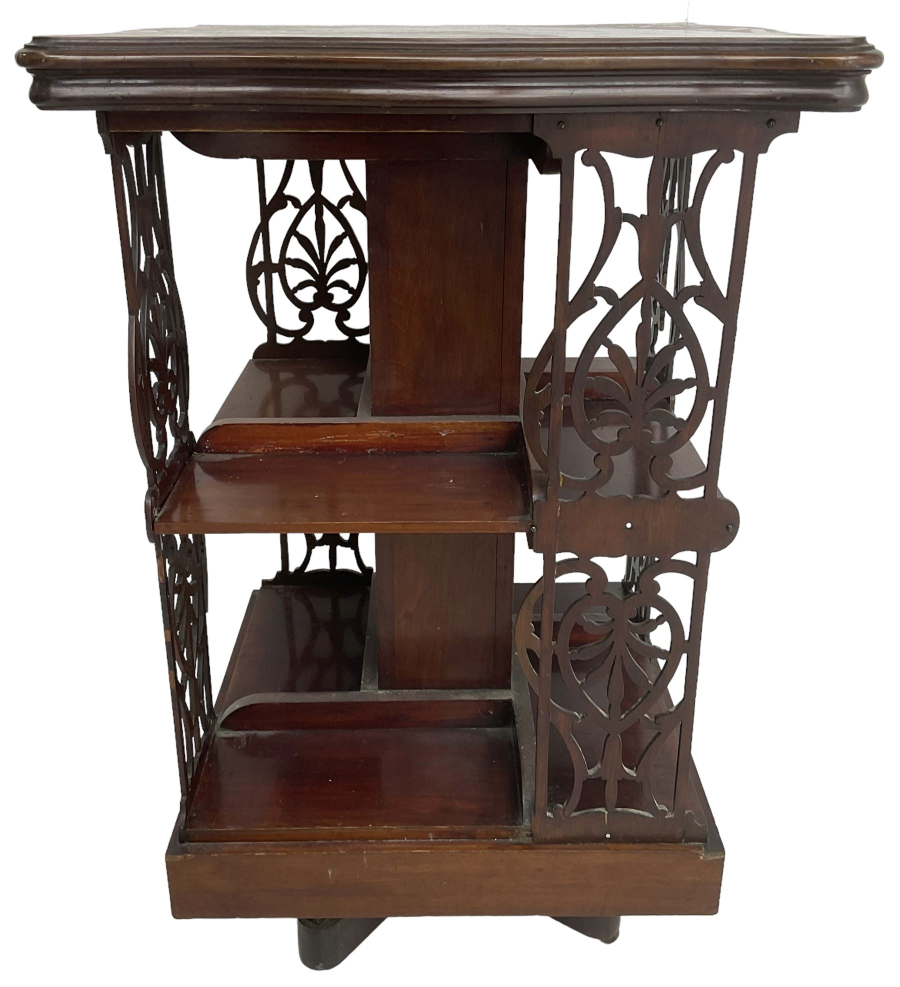 Edwardian mahogany revolving bookcase, the shaped moulded top inlaid with cusped panel and trailing bellflowers within a satinwood frame, foliate pierced upright splats and central square column supporting two tiers, on cruciform base with brass and ceramic castors 