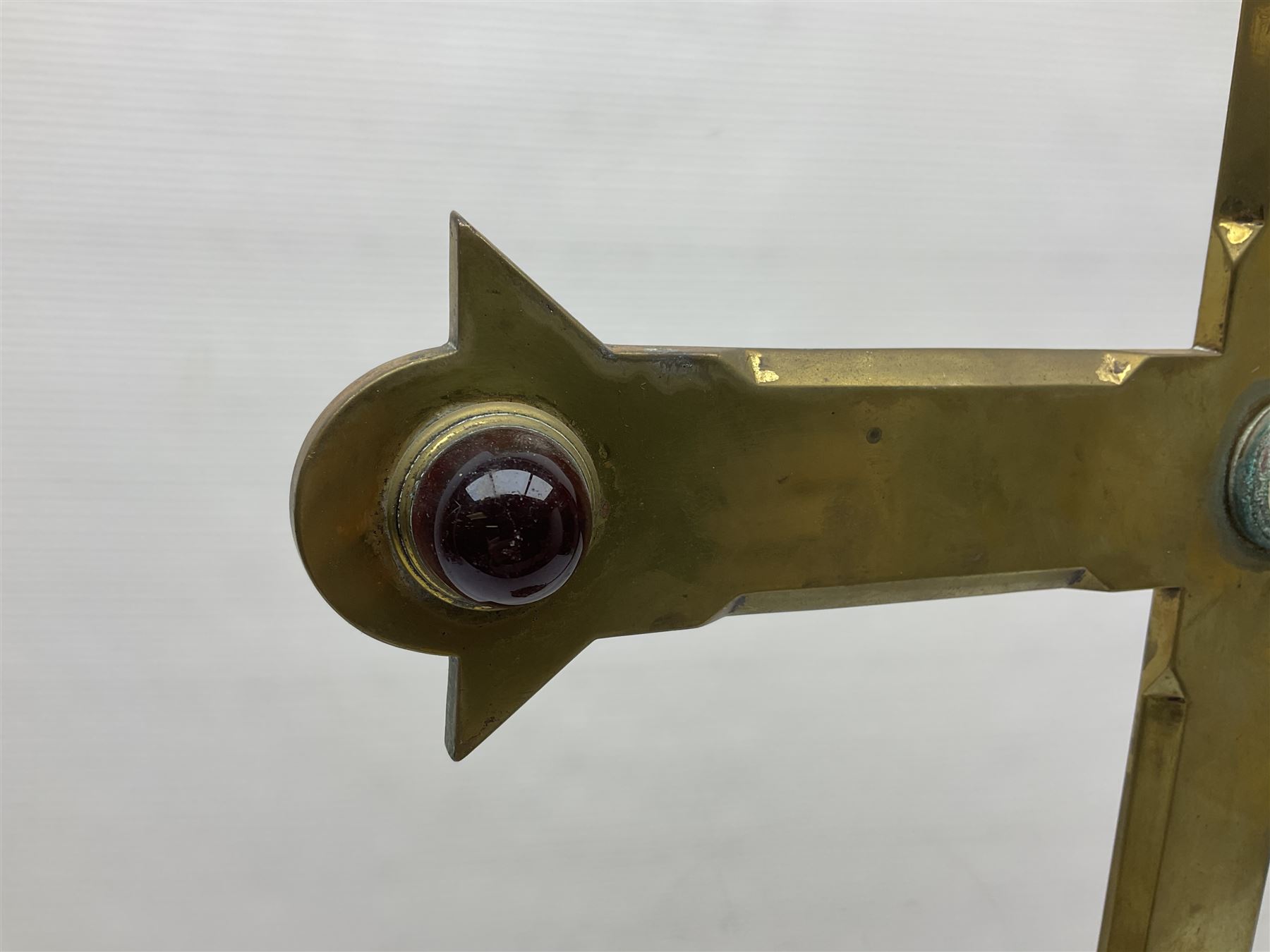 Brass alter cross, decorated with glass cabochons, upon a acicular stepped base and three claw feet, H73cm 