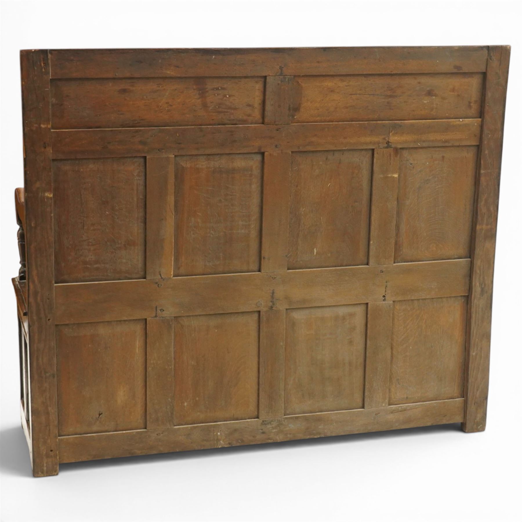 Victorian Jacobean Revival carved oak settle or hall bench with box seat, the cresting rail carved with repeating lunette motifs with acanthus and rosette decoration, over four back panels and hinged box seat, the panelled base raised on stile supports