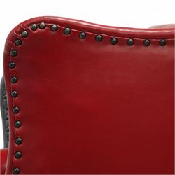 20th century Georgian design mahogany framed wingback armchair upholstered in red leather, shaped back flanked by winged sides and down-swept arms raised on squared legs 