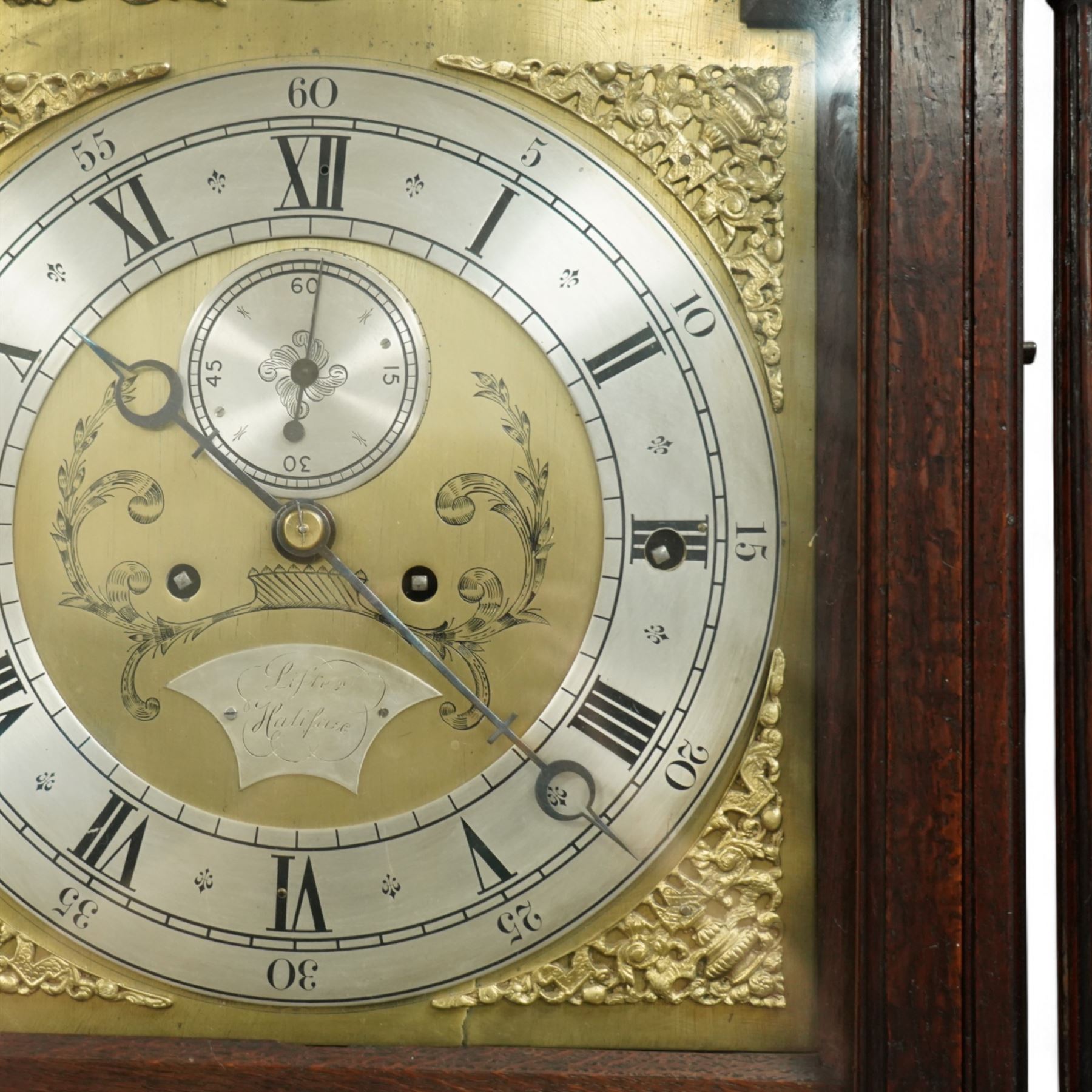 Lister of Halifax -  Oak cased musical longcase clock c1790, 8-day movement sounding the quarters and hours on bells or gong rods, case with a flat pediment and oval  conch inlay beneath, break arch hood door with reeded pilasters and brass Corinthian capitals, trunk with conforming quarter recessed pillars and a long wavy topped door, plinth with a raised panel and applied moulding the the base, break arch brass dial with cast spandrels and engraved dial centre, with a silvered chapter, seconds dial and cartouche with makers name, gongs or bells selector to the arch, chapter with Roman numerals, five minute Arabic's, minute track and steel moon hands, dial pinned directly to a three train weight driven movement with a nest of eight bells and eight gong rods, sounding the hours on either bells or gong rods, with a rack strike and recoil anchor escapement. With pendulum and weights.
The Lister family were a prodigious family of prolific clockmakers working in Halifax and the West Riding area of Yorkshire during the 18th and 19th century, well-known and noted for producing a number of chiming and musical longcase clocks.