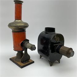 German late 19th century black tinplate toy magic lantern projector by Johannes Falk, embossed lighthouse logo, single removable lens, (lacking burner and chimney) H18cm, and early 19th century orange tinplate magic lantern projector on wooden stand, single removable lens and detachable chimney, H30cm