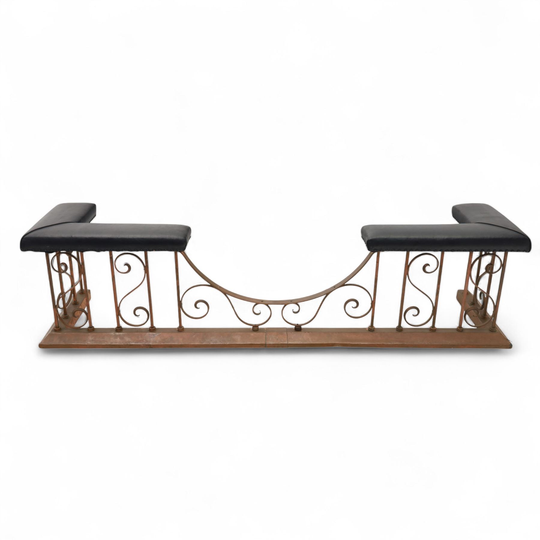 Early 20th-century Arts & Crafts copper club fender, of long serpentine form, scrolling uprights and a shaped centre support, the top rail fitted with four upholstered padded seat sections, raised on a stepped plinth base, inner dimensions 192x43cm 