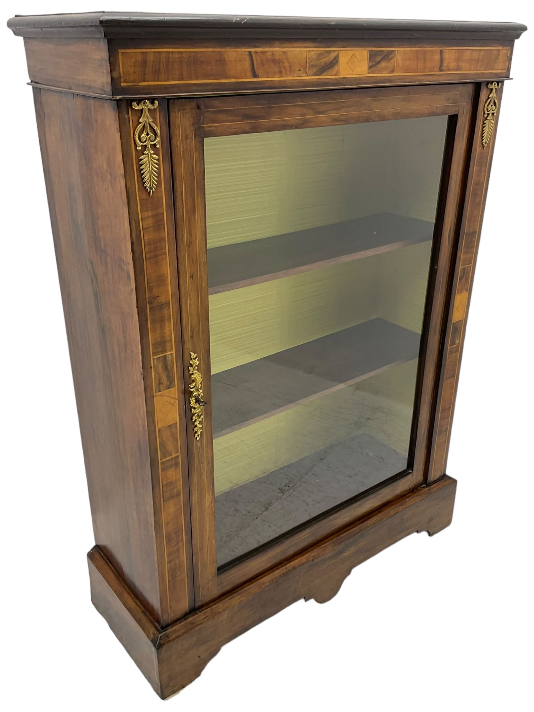 Victorian walnut pier cabinet, moulded rectangular top over inlaid frieze and uprights, enclosing by single glazed door, the interior fitted with two shelves, on shaped bracketed plinth base