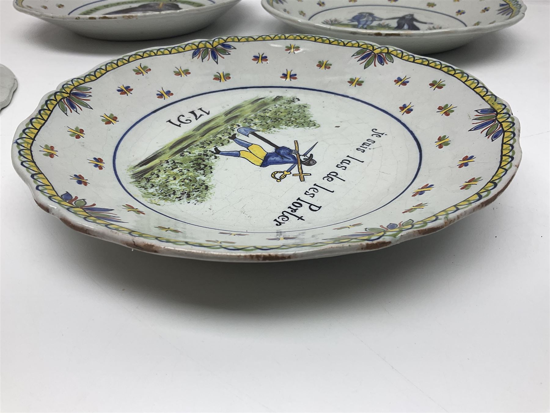 Four French Faience plates, comprising Je suis las de le porter, Le malheur nous reunit, Je desire y arriver and Eveque de Meaux, D24cm  