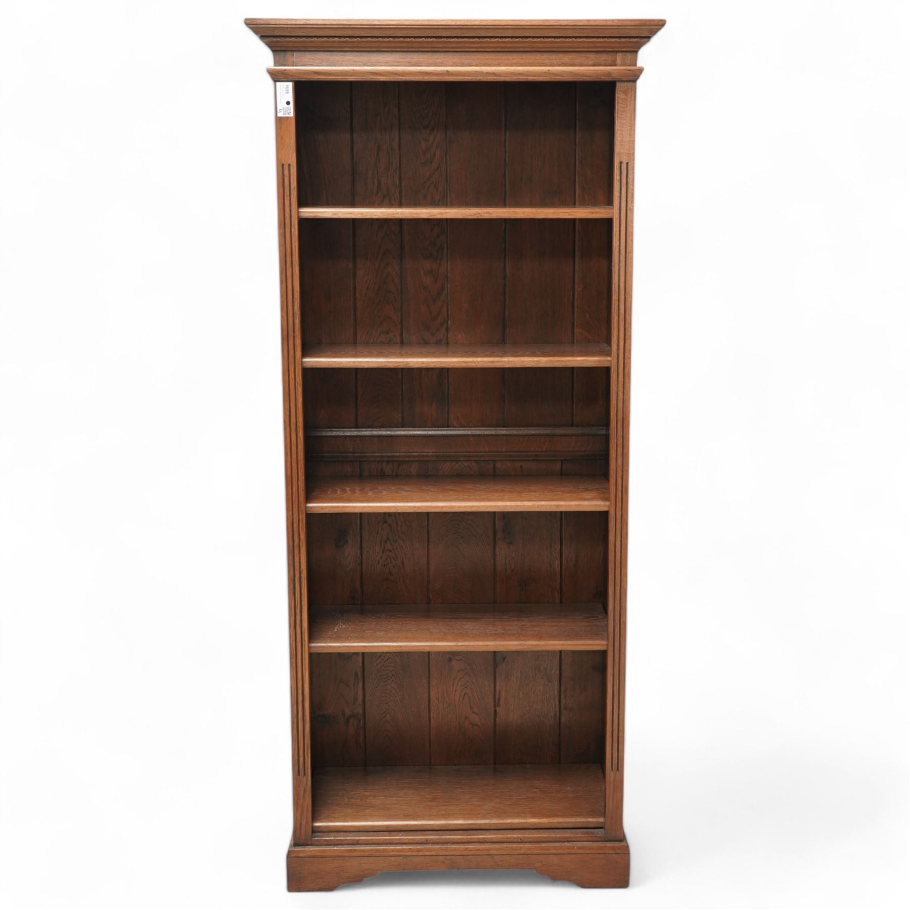 Oak open bookcase, projecting cornice over open front fitted with adjustable shelves, fluted uprights, on shaped bracket feet 