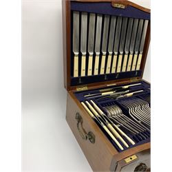 Late 19th/early 20th century composite canteen of silver flatware, contained within an early 20th century mahogany serpentine fronted case with twin drop carry handles, and hinged cover with boxwood stringing and central inlaid shell motif, above a single drawer with twin ring handles and Wellington style locking system, the cover and drawer opening to reveal plaque for Spink & Sons Ltd London, and fitted interior containing ivory handled knives, ivory handled carving set, and silver Hanoverian and Old English pattern cutlery, each with engraved monogram to terminal, hallmarked London, makers Spink & Son (John Marshall Spink), Goldsmiths & Silversmiths Co, and Chawner & Co (George William Adams), various dates ranging 1880-1923, gross weighable silver 92.59 ozt (2880 grams)