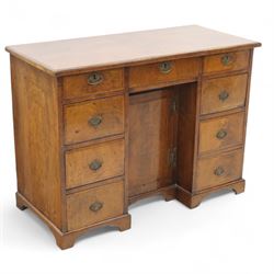 Early 20th-century Georgian-style walnut kneehole desk, the rectangular top with feather c...