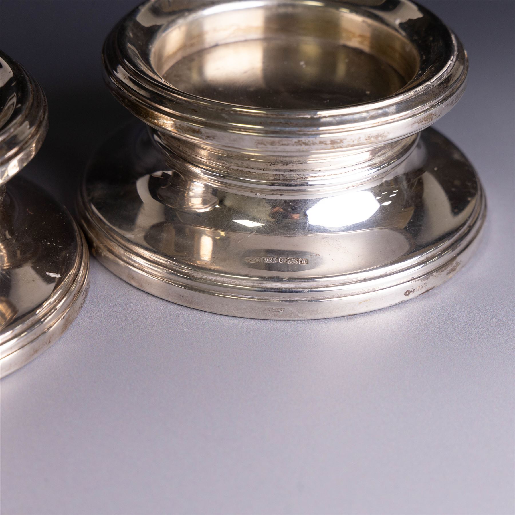 Pair of modern silver mounted candle holders, of circular stepped form, hallmarked Broadway & Co, Birmingham 2006, H5.5cm, D11cm
