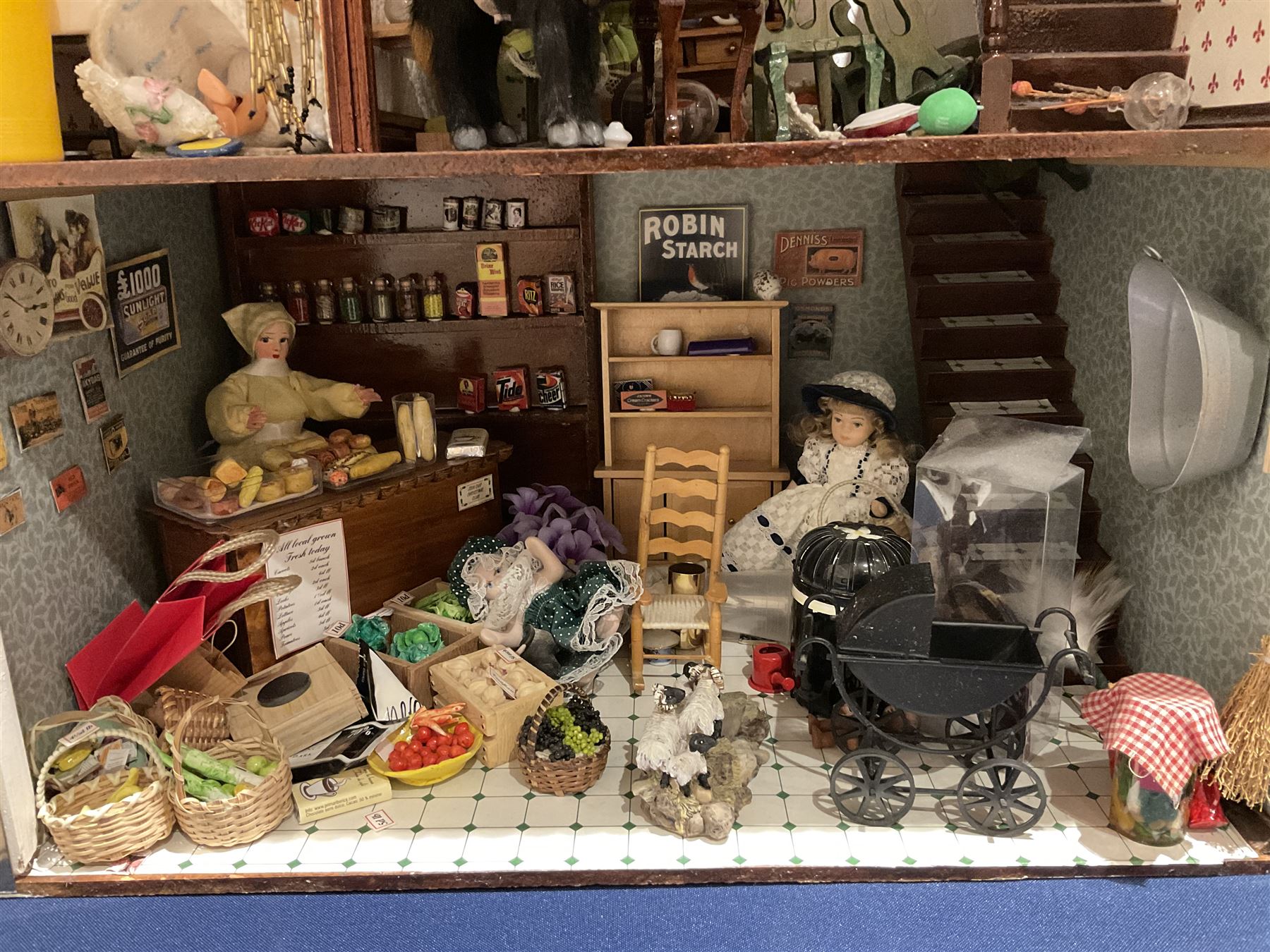 Seagull Pub - scratch-built wooden doll's house as a two-storey gable fronted public house painted in white green and maroon; the hinged front with ground floor veranda and window over opening to reveal two fully furnished rooms with dog-leg staircase and well stocked bar with bar-tender L31cm H62cm D37cm; together with Corner Shop and Dollies Pantry; a similarly painted scratch-built wooden two-storey flat-roofed doll's house as a well stocked ground floor grocery shop with stairs up to two further fully furnished rooms and more stairs giving access to a roof terrace L46cm H57cm D33cm (2)