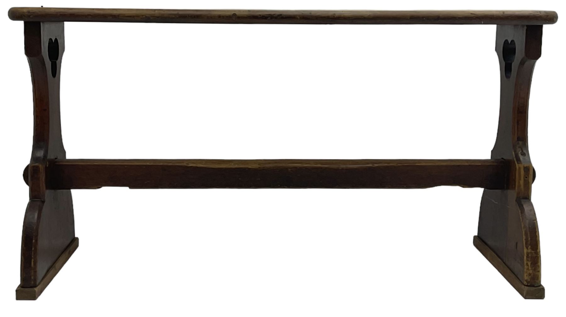 Late Victorian ecclesiastical pitch pine side table, rectangular bow-front top, on shaped end supports pierced with quatrefoils, united by pegged stretcher 