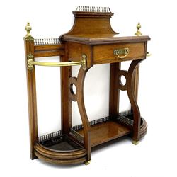 Late Victorian oak umbrella and stick hall-stand, the top fitted with brass balustrade and finials, central drawer flanked by curved ends each with curved brass bars and metal drip trays, central undertier 