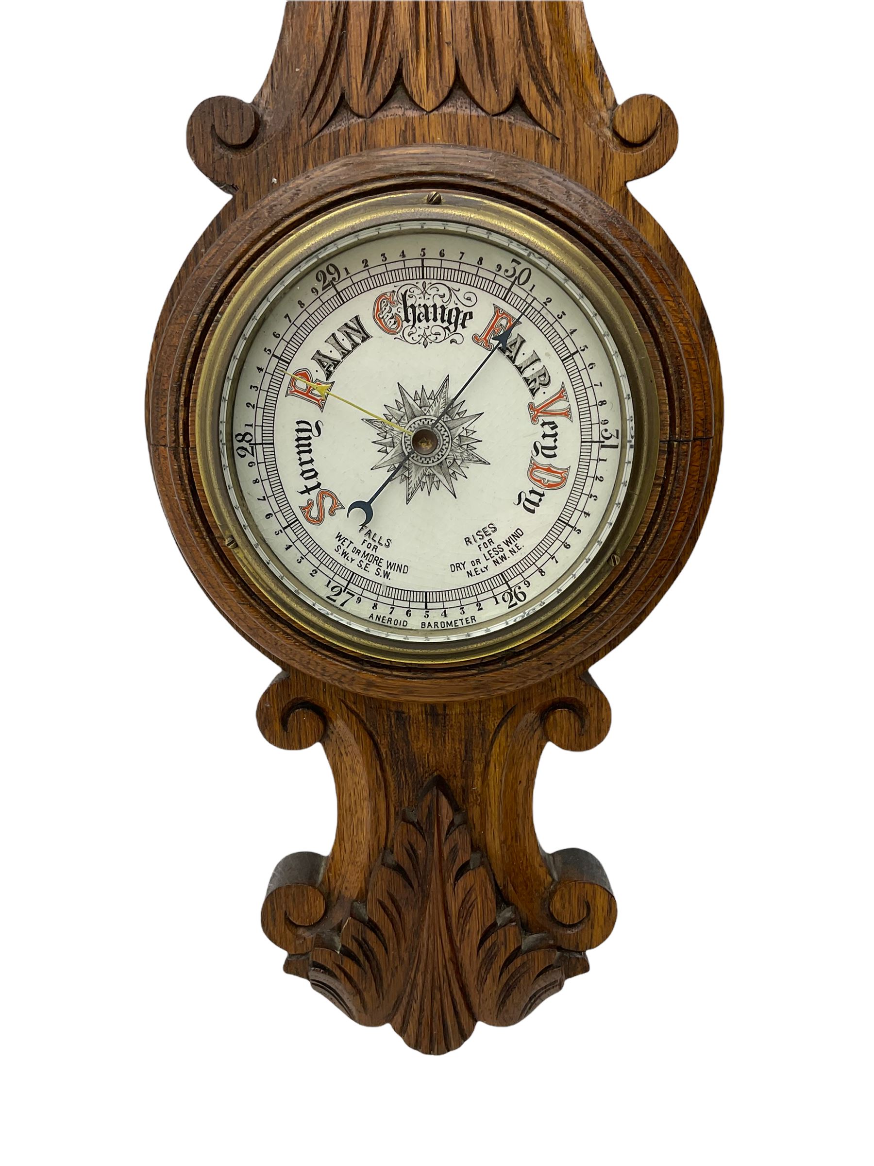 A carved oak cased aneroid barometer with a 5” register, measuring barometric pressure from 26