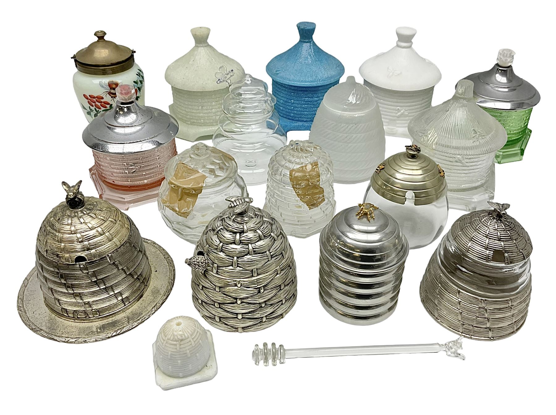 Collection of glass beehive honey pots, to include a blue slag example, milk glass, pink, green, etc together with four white metal examples (16) 
