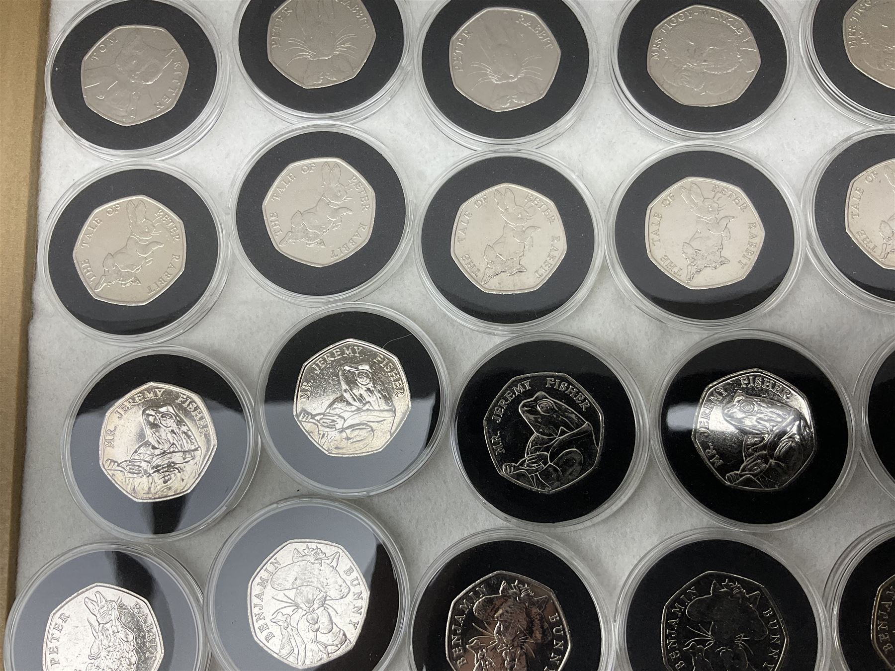 Thirty-seven commemorative fifty pence coins, including 2011 wrestling, other Olympics, Beatrix Potter etc, housed in capsules