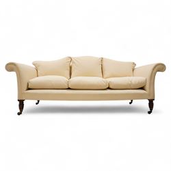 Grande three-seat camelback sofa, upholstered in calico base layer, on turned feet painted to resemble rosewood, fitted with brass cups and castors