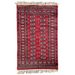 Tekke Bokhara red ground rug, decorated with two rows on Gul motifs, geometric design borders decorated with stylised floral motifs 
