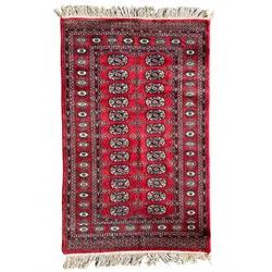 Tekke Bokhara red ground rug, decorated with two rows on Gul motifs, geometric design borders decorated with stylised floral motifs 